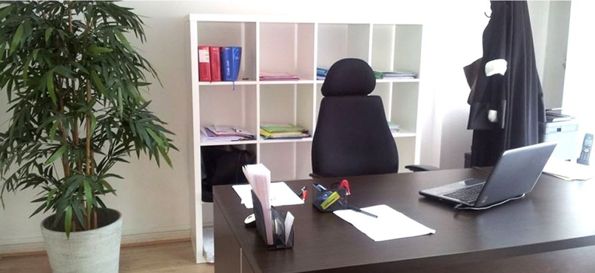 Bureau moderne avec bureau, ordinateur portable, chaise, étagères, plante et porte-manteau