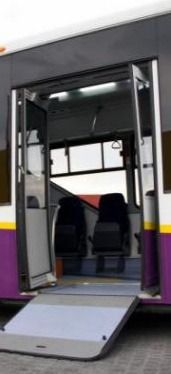 Un autobús morado y blanco con las puertas abiertas.