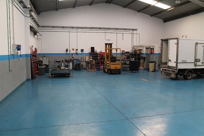 Un almacén con una carretilla elevadora y un camión dentro.