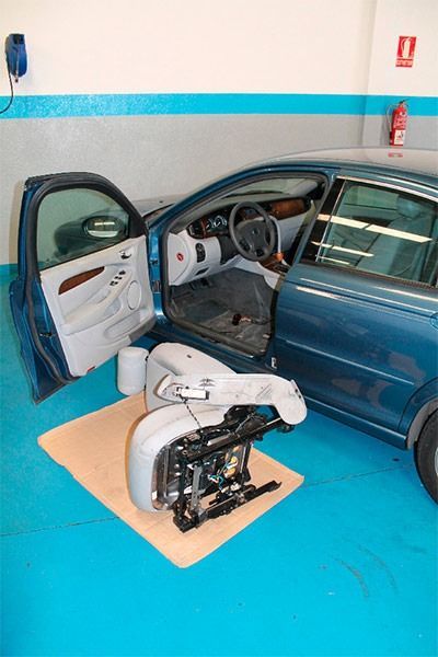 Un coche azul está estacionado en un garaje con la puerta abierta.