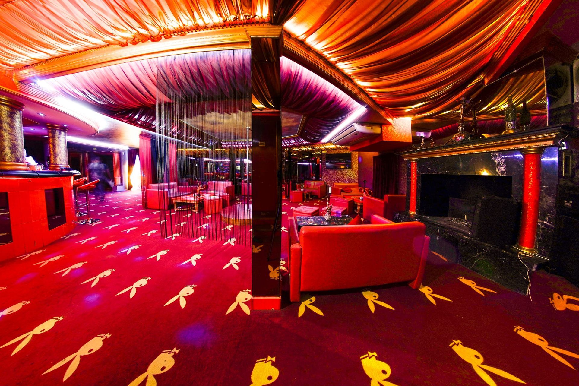 Una habitación grande con un sofá rojo y una alfombra roja.