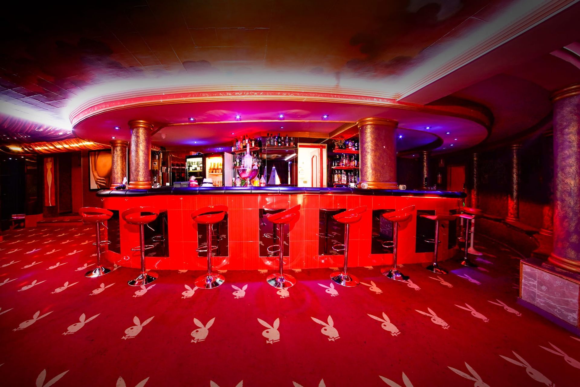 Hay un bar en el medio de la habitación con una alfombra roja.