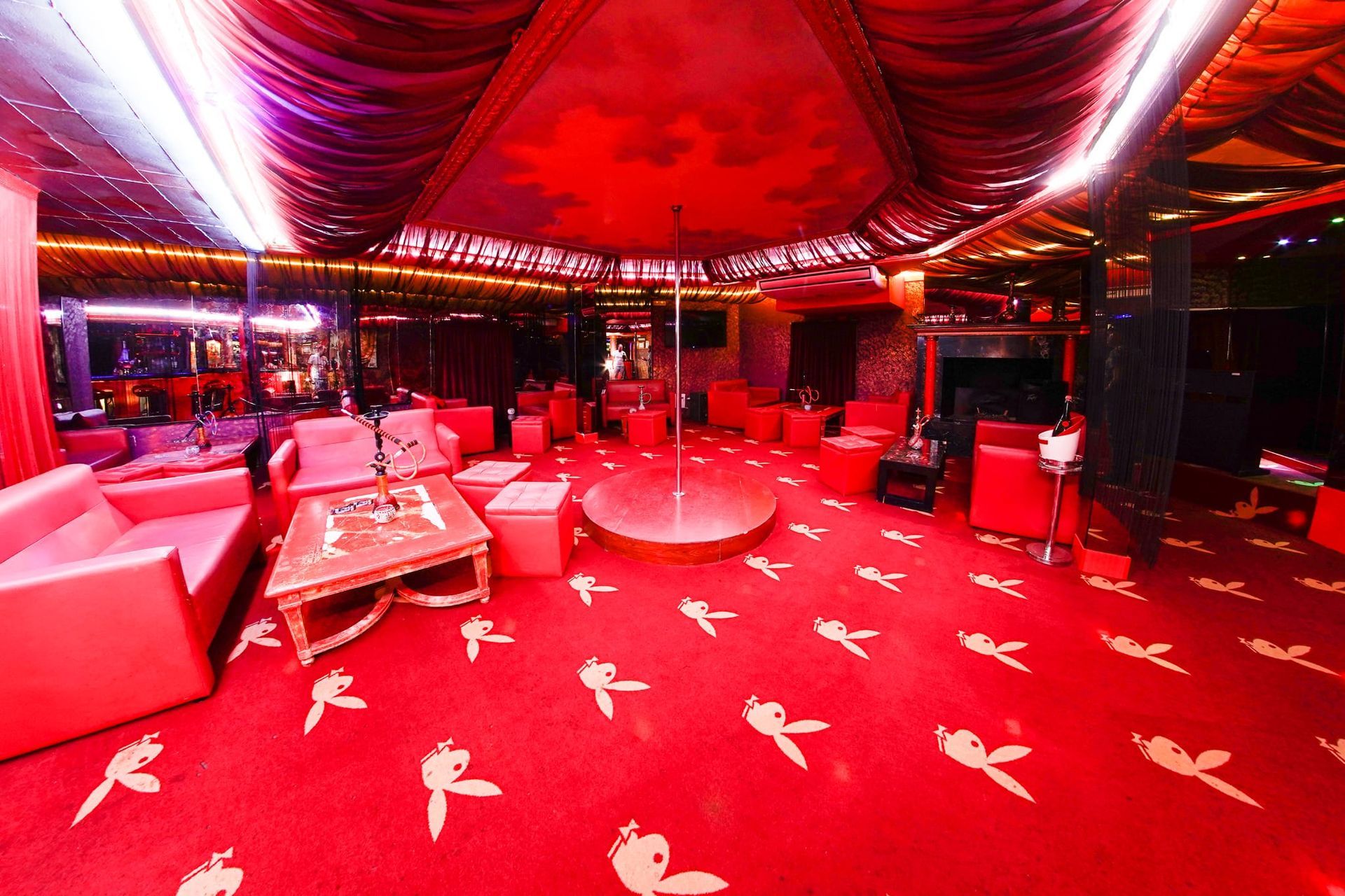 Una gran sala con una alfombra roja y un poste en el medio.