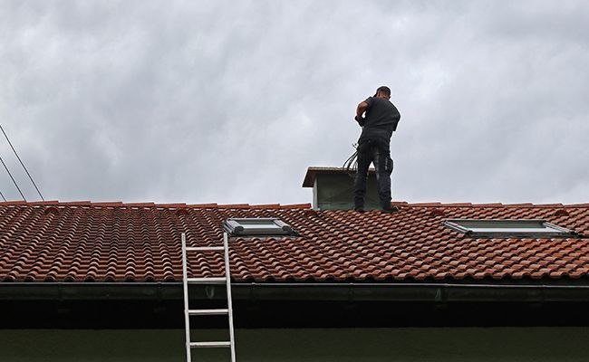 Homme sur une toiture par un temps grisâtre