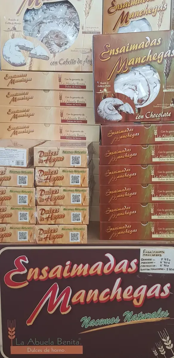 Menú de Ensaladas Manchegas con precios y fotos de los platos en una pared beige.