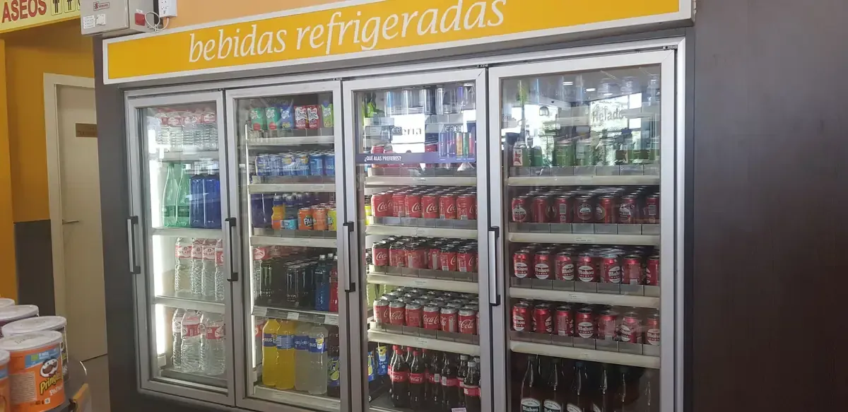 Vitrina refrigerada para bebidas con refrigeradores de puerta de vidrio surtidos con bebidas en una tienda.