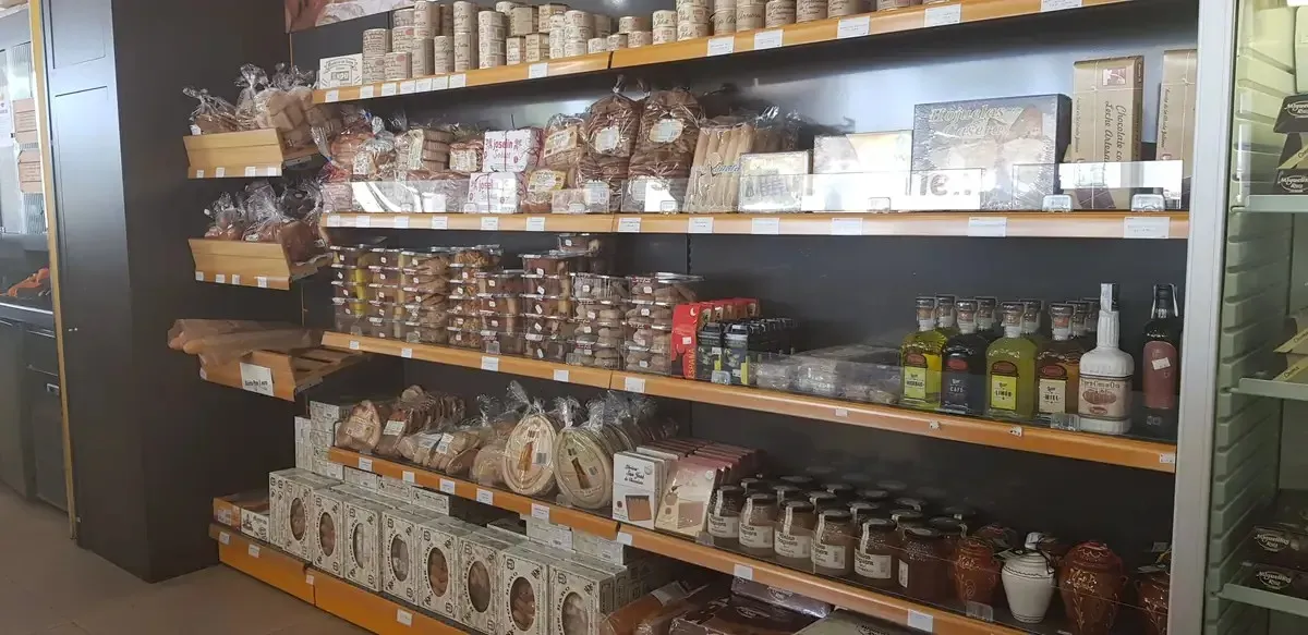 Estantería de supermercado repleta de frascos, botellas y productos envasados.
