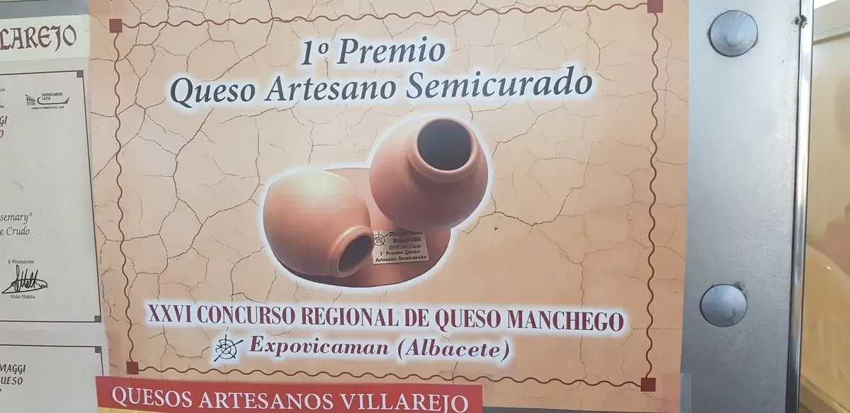 Award plaque for “1º Premio Queso Artesano Semicurado” with cheese wheel illustration and sponsor logos.