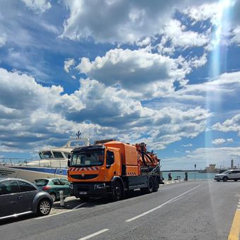 Camion d'assainissement garé devant un bateau