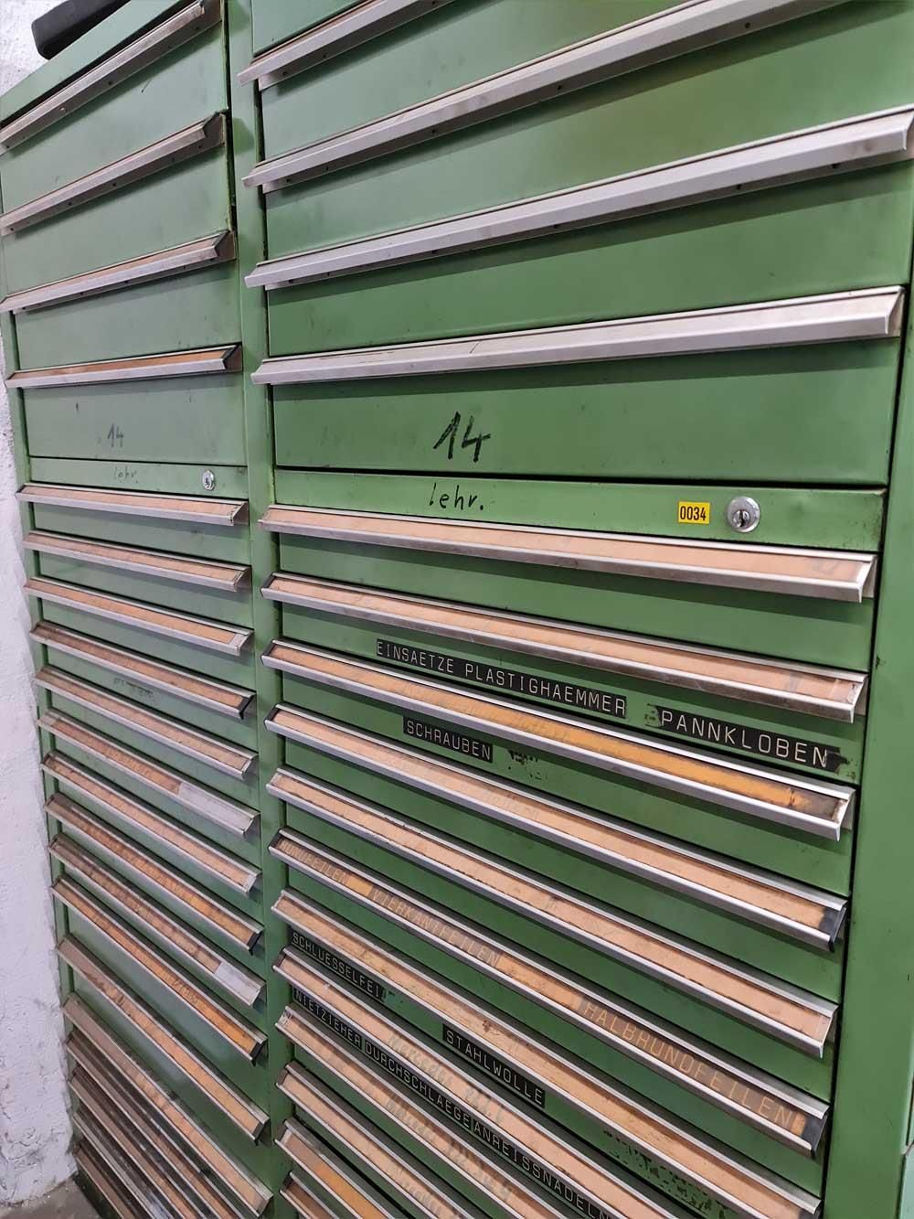 Eine Reihe grüner Schränke mit Holzschubladen in einem Zimmer.