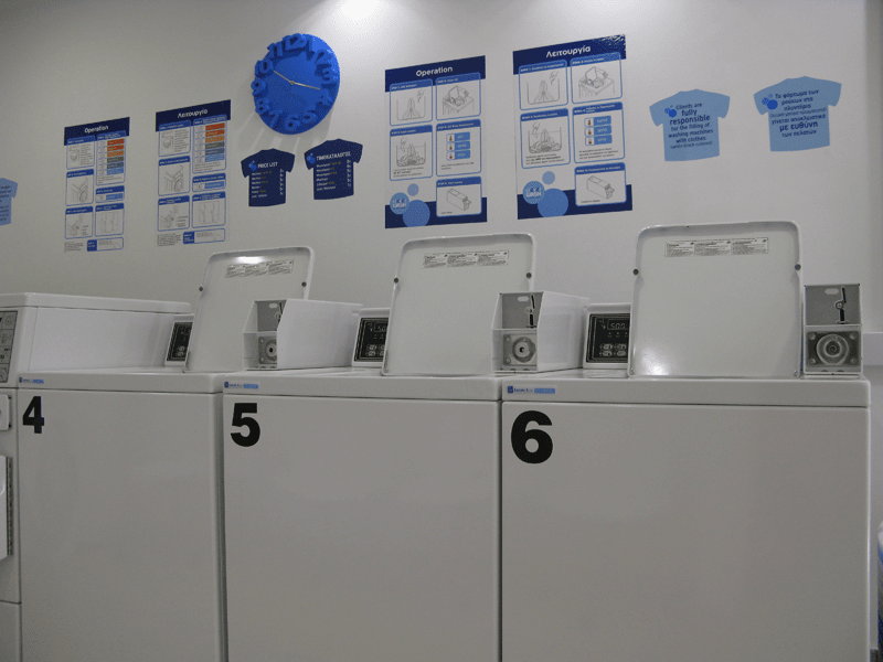 Ένα πλυντήριο με λευκά πλυντήρια και στεγνωτήρια με αριθμούς 4, 5, 6 και 7