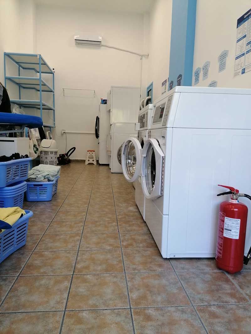 Ένα πλυντήριο με πυροσβεστήρα στο πάτωμα.