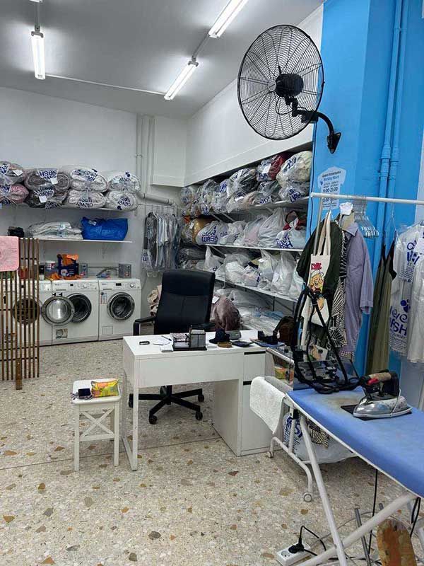 Πλυντήριο με γραφείο, καρέκλα και σιδερώστρα.