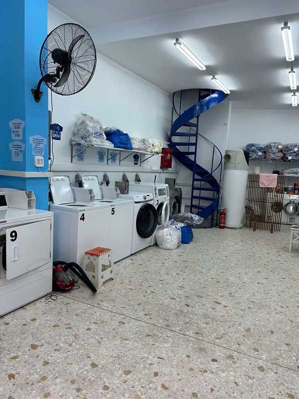 Ένα πλυντήριο με σπειροειδή σκάλα και ανεμιστήρα στον τοίχο.