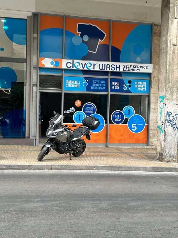 Μια μοτοσικλέτα είναι παρκαρισμένη μπροστά από ένα έξυπνο πλυντήριο ρούχων.