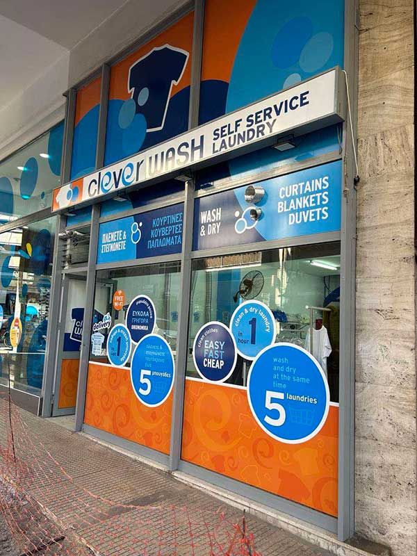 Ένα πλυντήριο με μια πινακίδα που γράφει «έξυπνο πλύσιμο, πλυντήριο αυτοεξυπηρέτησης».