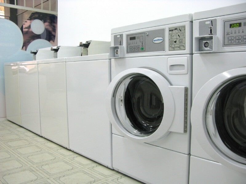 Μια σειρά από λευκά πλυντήρια και στεγνωτήρια σε ένα πλυντήριο