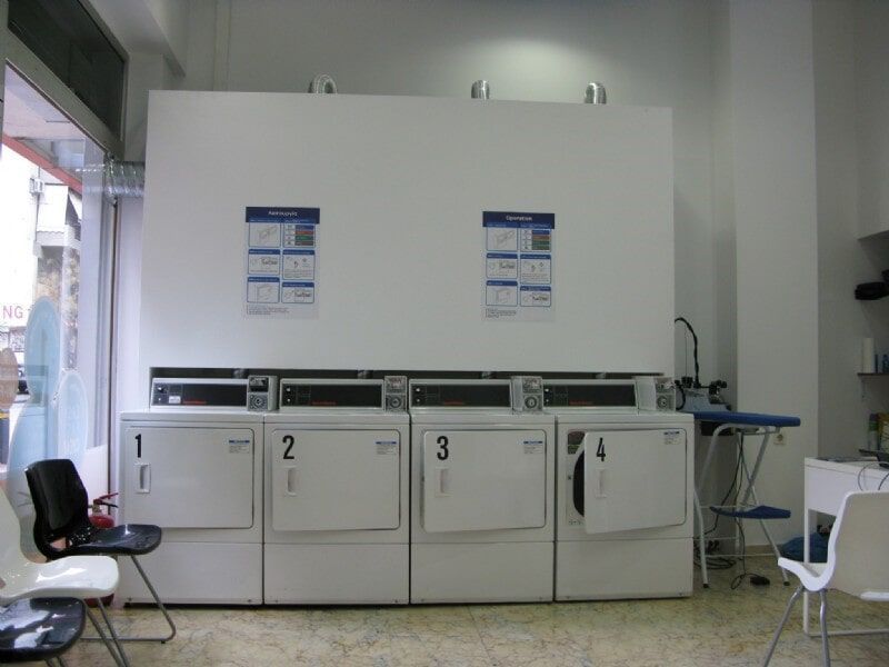 Ένα πλυντήριο ρούχων με πλυντήρια και στεγνωτήρια με τους αριθμούς 1, 2 και 3 πάνω τους