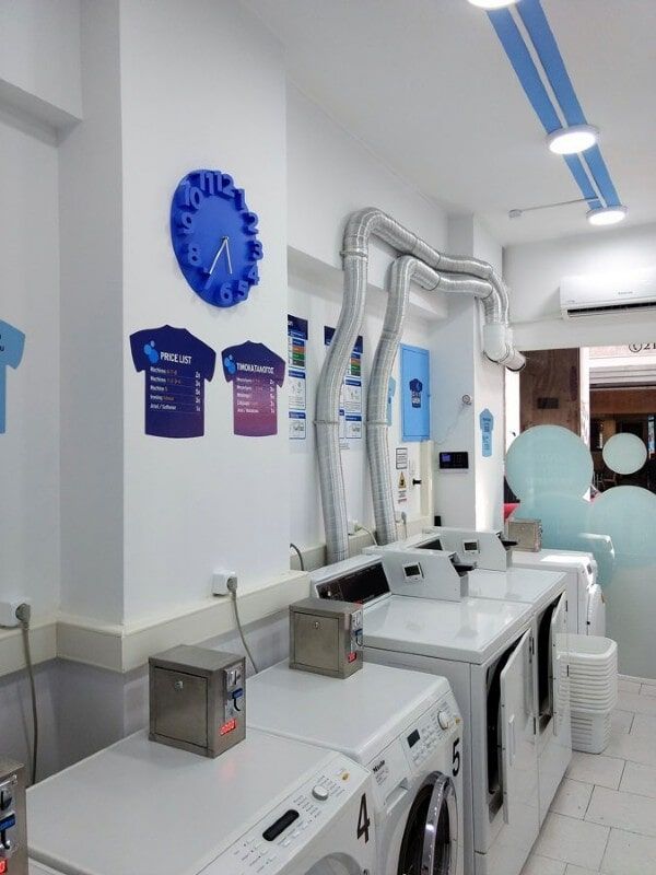 Ένα πλυντήριο με ένα μπλε ρολόι στον τοίχο