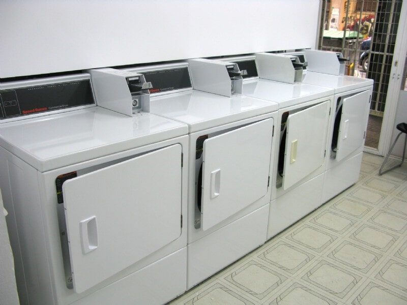 Μια σειρά από λευκά πλυντήρια και στεγνωτήρια σε ένα πλυντήριο