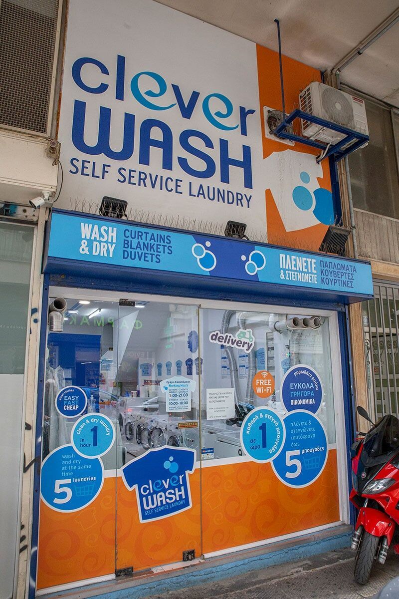 Μια μοτοσικλέτα είναι παρκαρισμένη μπροστά από ένα έξυπνο πλυντήριο αυτοεξυπηρέτησης.