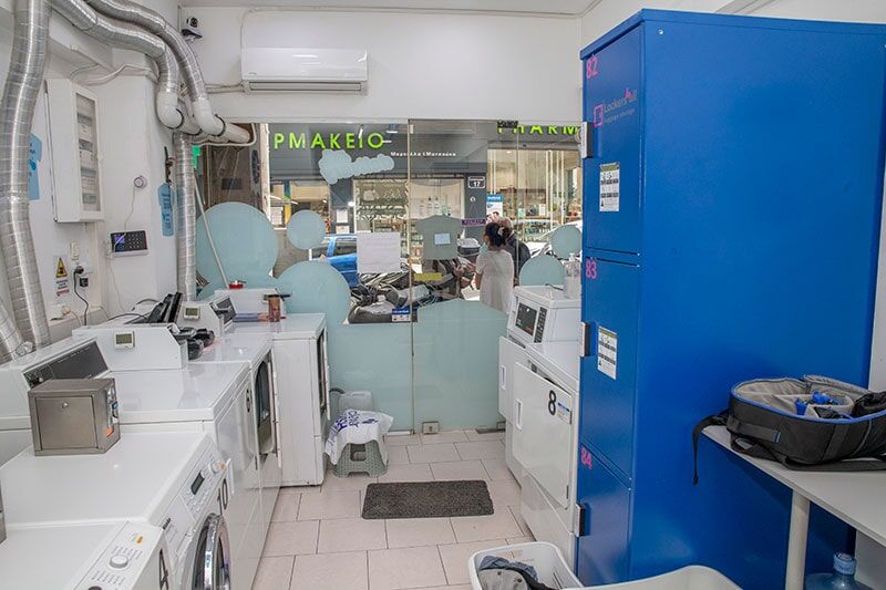 Ένα πλυντήριο ρούχων με πολλά πλυντήρια και στεγνωτήρια.