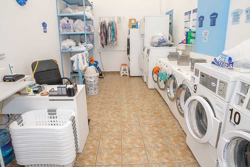 Ένα πλυντήριο με πολλά πλυντήρια ρούχων και ένα γραφείο.