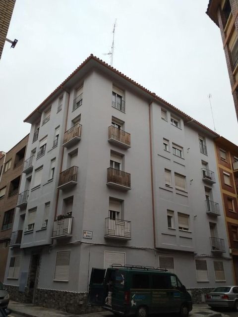 Un edificio con una camioneta estacionada enfrente.