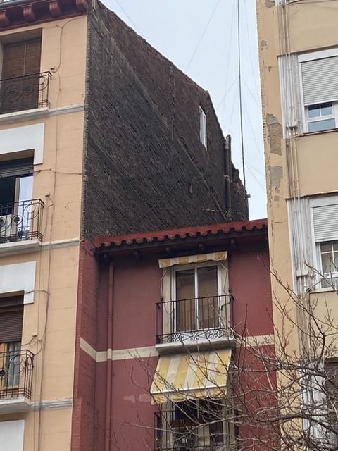Un edificio con un balcón en el lateral.