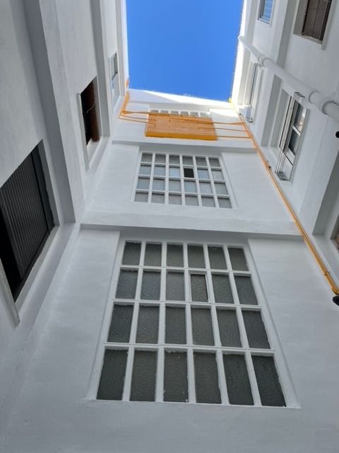 Mirando hacia arriba a un edificio con un cielo azul en el fondo