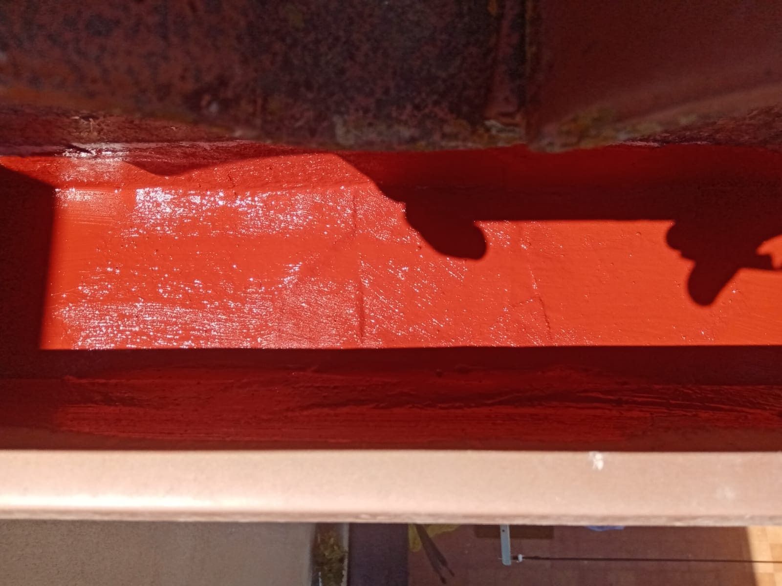 La sombra de una persona se proyecta sobre una superficie roja.