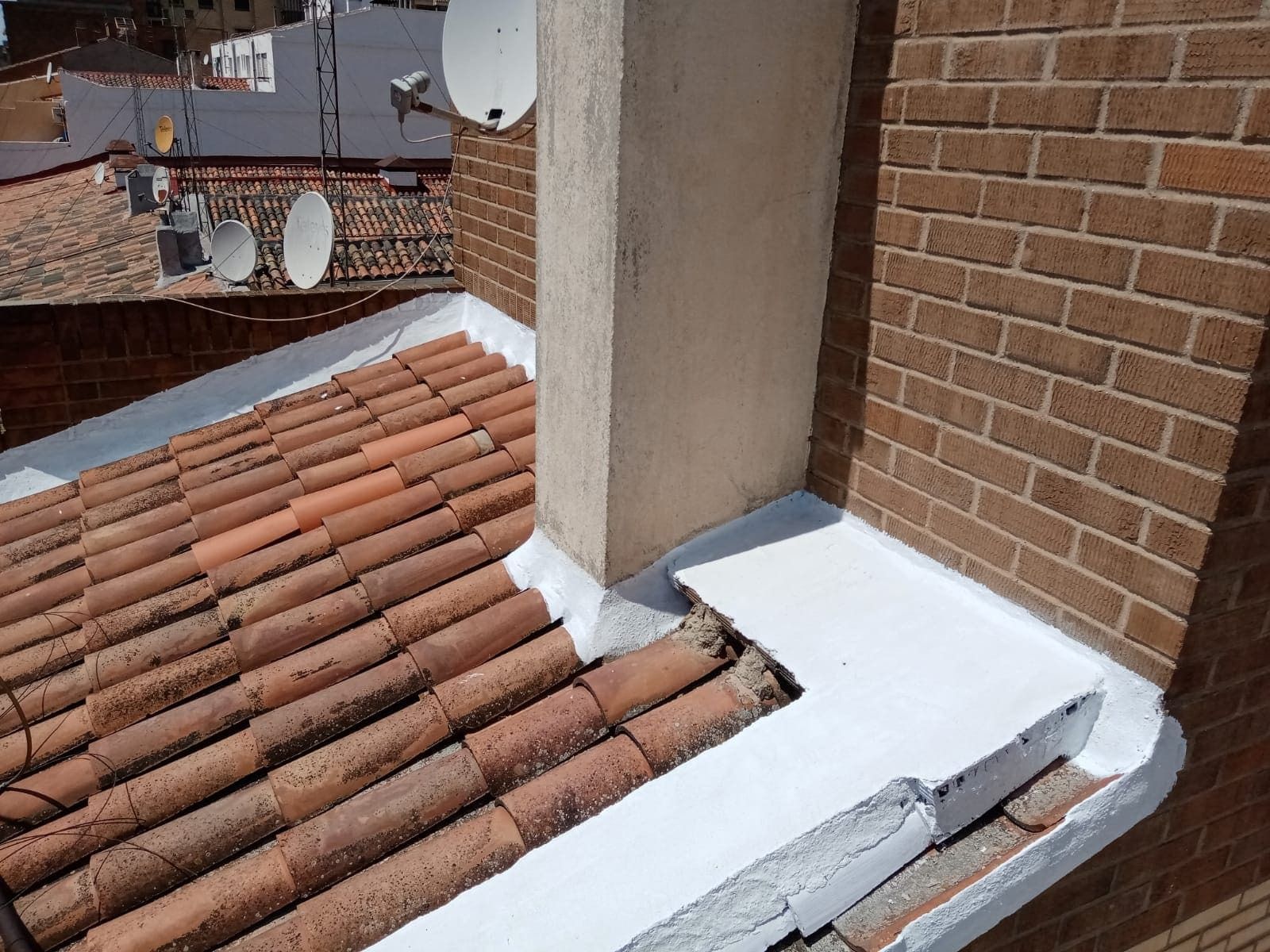 Un techo con chimenea y antenas parabólicas.