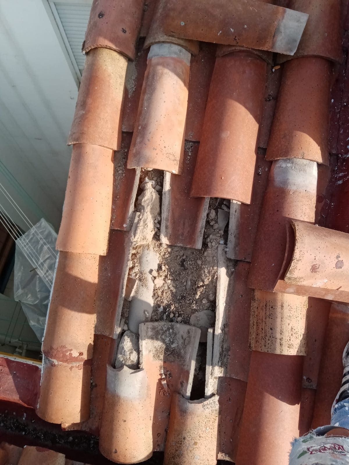 Un primer plano de un tejado con muchas tejas rotas.