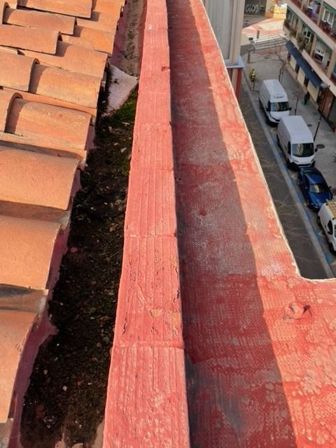 Una pared roja con un desagüe a un lado.