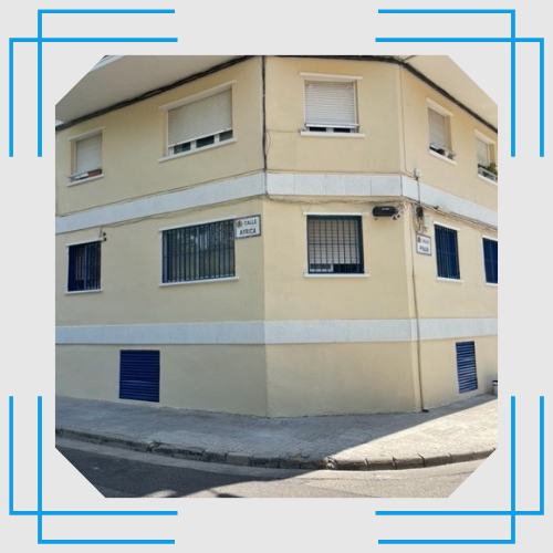 Una esquina de un edificio con una ventana azul.