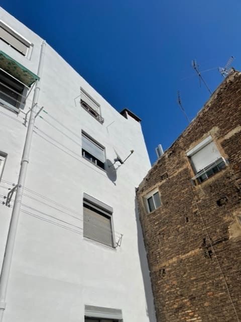 Un edificio blanco con una antena parabólica encima.