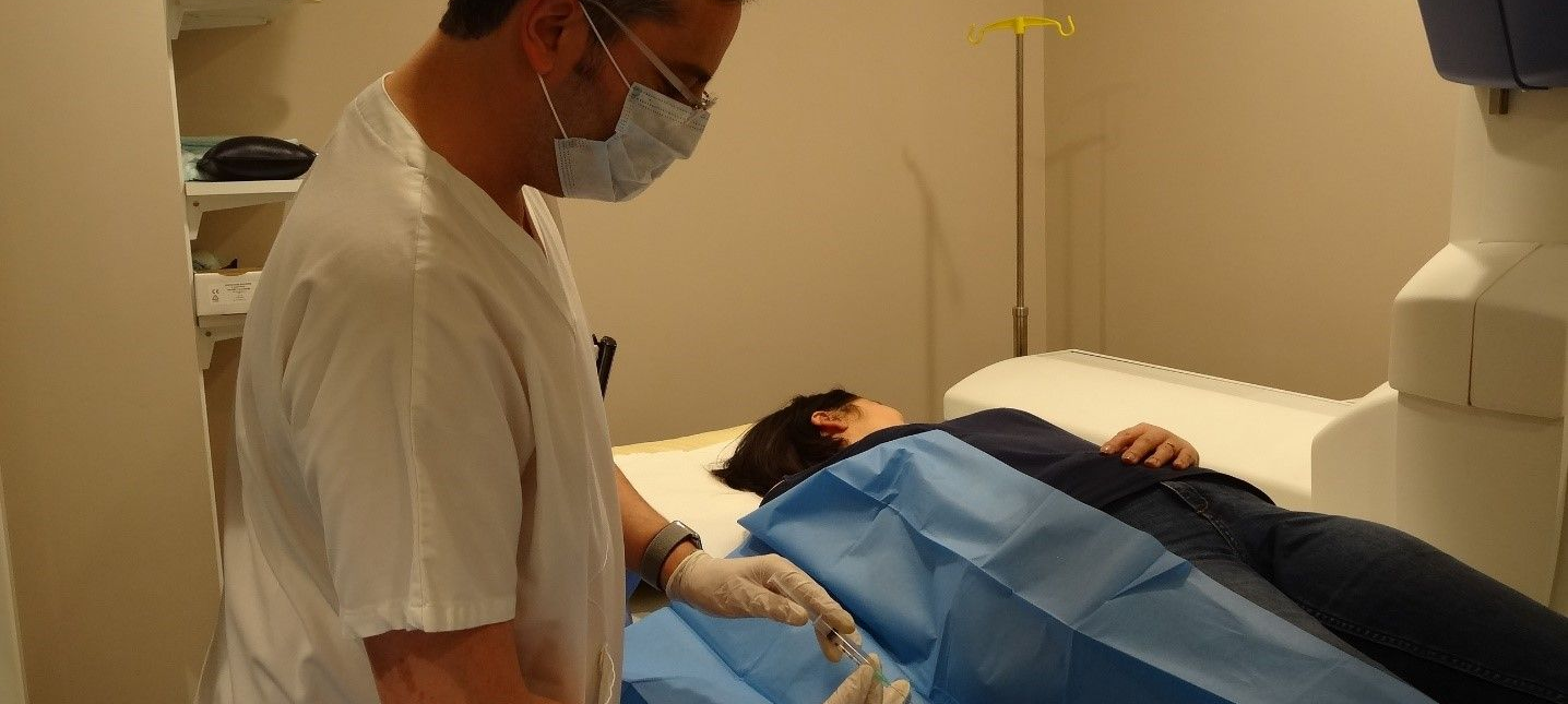 Personnel médical effectuant une échographie sur un patient allongé sous une couverture bleue