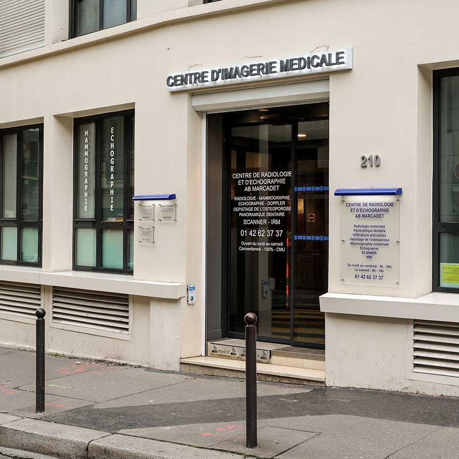 Entrée d'un centre d'imagerie médicale blanc avec porte vitrée et enseigne française en façade