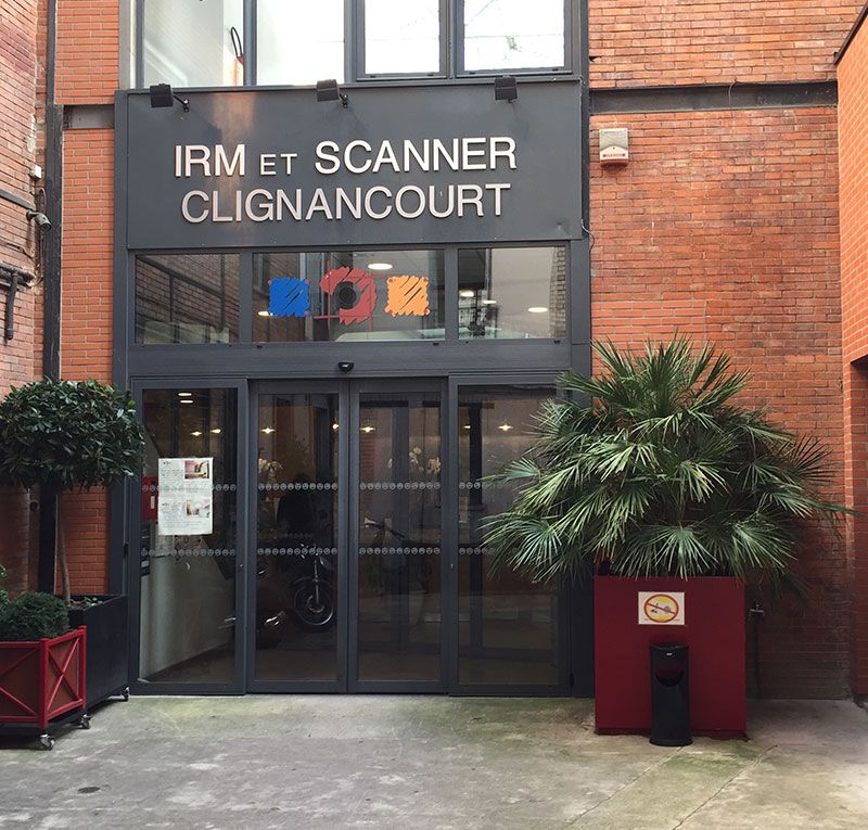 Entrée de la clinique d'imagerie médicale IRM et Scanner Clignancourt, avec portes vitrées et palmiers en pot.
