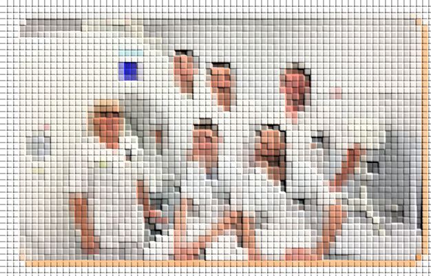 Groupe de personnes vêtues de blanc, assises et debout dans une pièce lumineuse, une personne levant la main