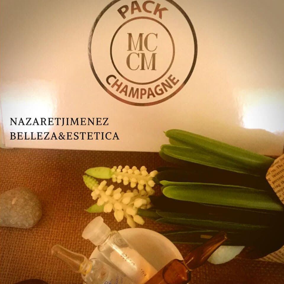 Primer plano de un expositor de productos de belleza con flores, verdes y una caja etiquetada 