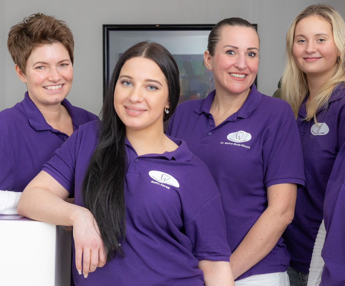 Eine Gruppe von Frauen in lila Hemden posiert für ein Foto | Zahnarztpraxis am Wall Dr. Bode-Hirsch