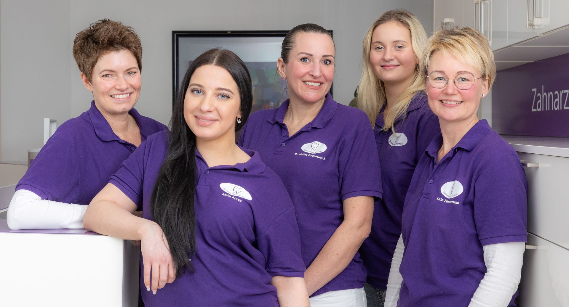 Eine Gruppe von Frauen in lila Hemden posiert für ein Foto | Zahnarztpraxis am Wall Dr. Bode-Hirsch