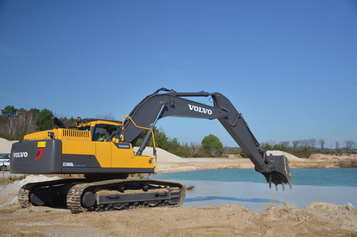 Tractopelle qui s'apprête à fouiller un étang