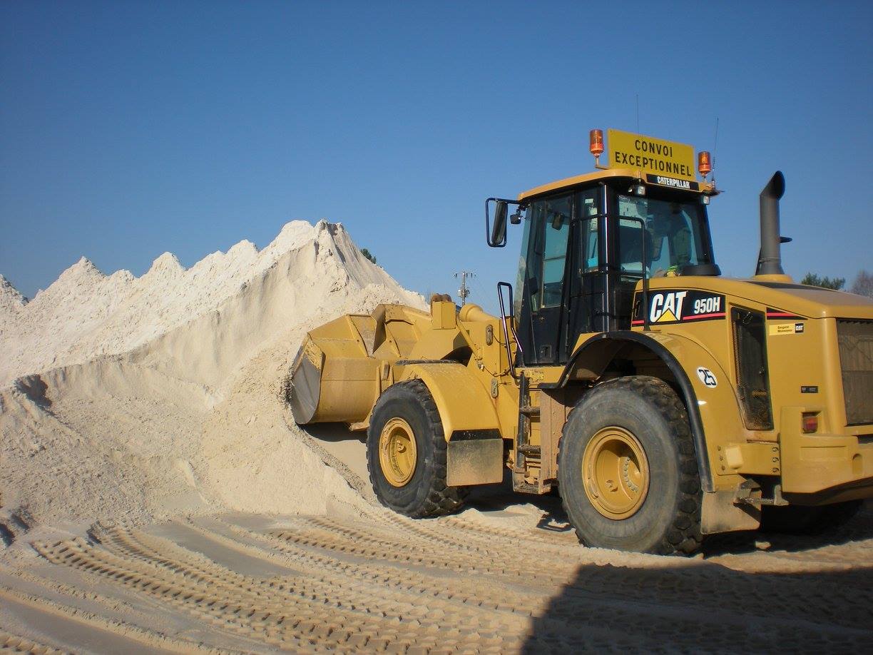 Tractopelle qui charge du sable jaune