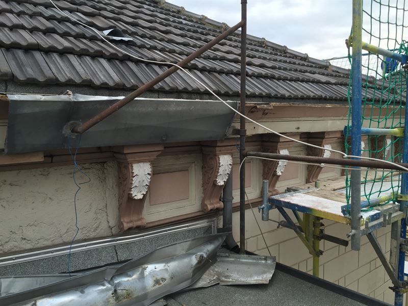 Das Dach eines Gebäudes wird mithilfe eines Gerüsts repariert.