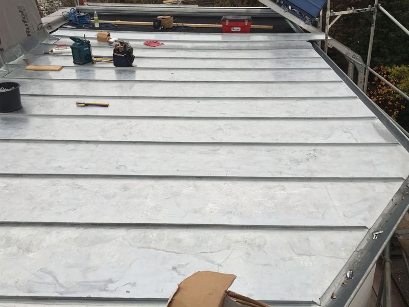 Ein Metalldach wird mit Werkzeugen darauf gebaut