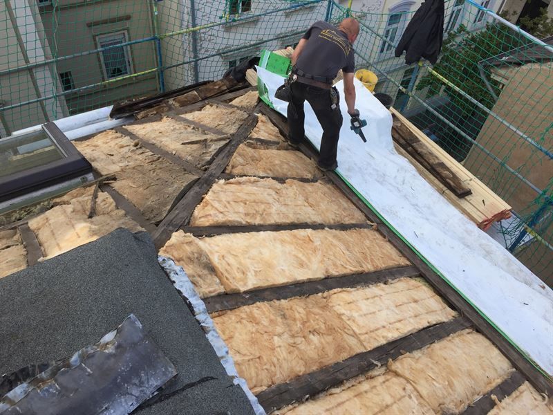 Ein Mann arbeitet auf dem Dach eines Gebäudes.