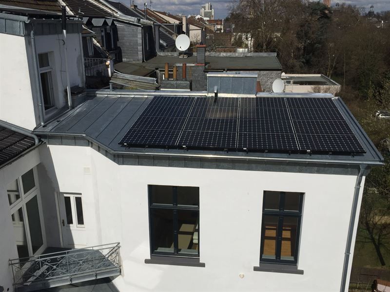 Ein weißes Gebäude mit Sonnenkollektoren auf dem Dach