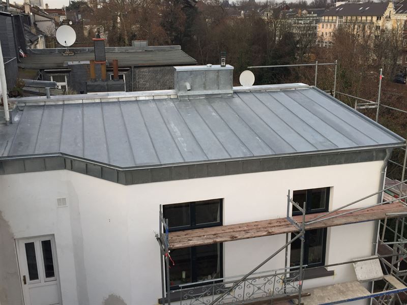 Ein weißes Gebäude mit einem Metalldach und einem Gerüst darum